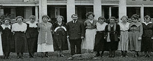 Group shot of faculty, students and headmaster in front of the college