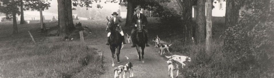 Chevy Chase Maryland Man and Woman on horseback with dogs riding to Fox Hunt