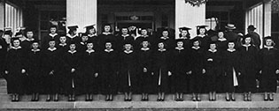 Image of graduates on college steps wearing caps and gowns 